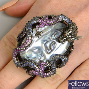 An 18ct gold dragon and blister pearl Buddha dress ring, set with vari-hue sapphire and 'brown' diamonds.