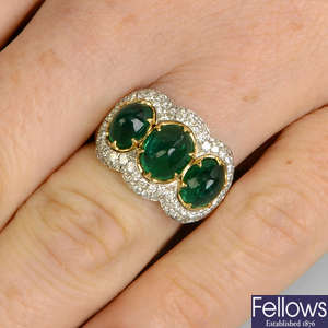 An emerald cabochon three-stone ring, with pave-set diamond surround.