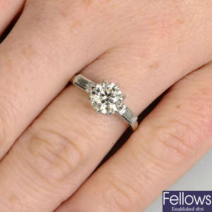 A platinum brilliant-cut diamond single-stone ring, with baguette-cut diamond sides.