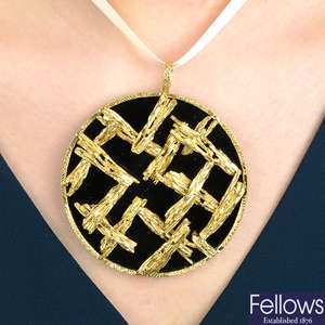 A 1970s 18ct gold onyx disc pendant with textured lattice overlay, by Kutchinsky.