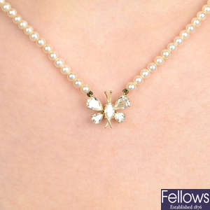 A diamond butterfly pendant on seed pearl strand, by Kutchinsky.