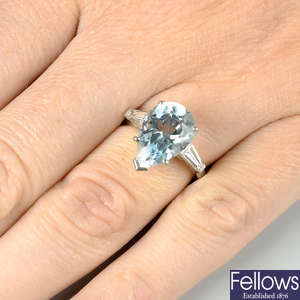 A platinum aquamarine single-stone ring, with tapered baguette-cut diamond shoulders, by Kutchinsky.