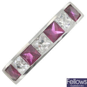 A platinum square-shape ruby and diamond half eternity ring.