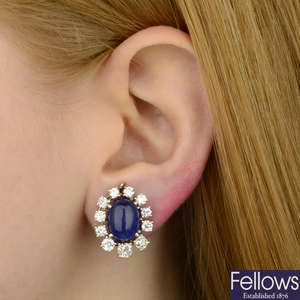 A pair of sapphire cabochon and graduated diamond cluster earrings.