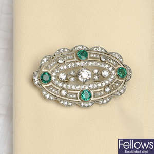 An early 20th century platinum Belle Époque emerald and diamond floral cluster brooch.