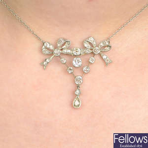 An early 20th century old-cut diamond bow pendant, on later chain.