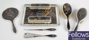 An early George V silver mounted & tortoiseshell part dressing table set, plus a similar button hook and shoe horn.