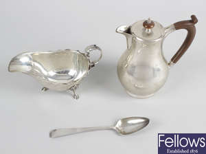 An Edwardian silver sauce boat, together with a 1920's silver hot water pot & a George III silver dessert spoon. (3).