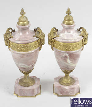 A pair of early 20th century pink marble and gilt metal mounted pedestal urns.