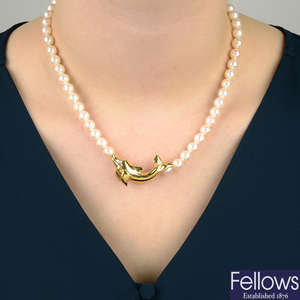 A cultured pearl single-strand necklace, with dolphin highlight, by Cartier.