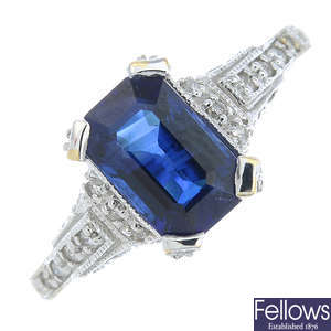 A sapphire single-stone ring, with pave-set diamond gallery and shoulders.