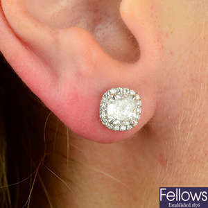 A pair of platinum cushion-shape and brilliant-cut diamond cluster earrings.