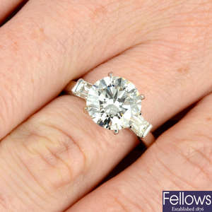 An 18ct gold brilliant-cut diamond single-stone ring, with baguette-cut diamond shoulders.