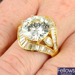 A brilliant-cut diamond ring, with pear-shape diamond sides and baguette-cut diamond surround.