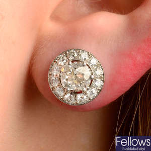 A pair of old-cut diamond stud earrings, with detachable brilliant-cut diamond halo surrounds.