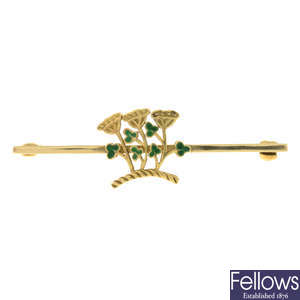 An 18ct gold bar brooch featuring an enamel shamrock and clover flower motif.