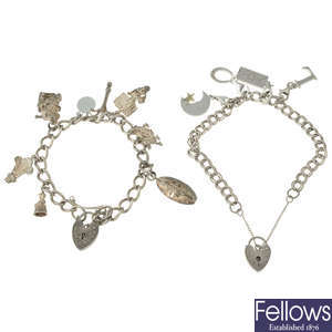 Five silver charm bracelets together with assorted charms.