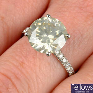 A brilliant-cut diamond single-stone ring, with diamond line shoulders.