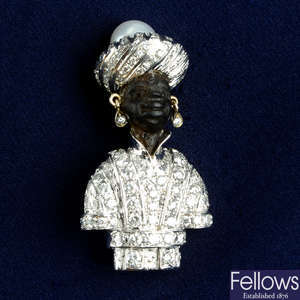 A carved ebony, pavé-set diamond and cultured pearl Blackamoor brooch.