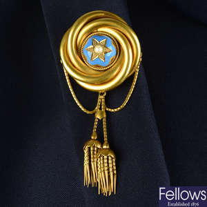 A mid to late Victorian gold stylised knot brooch, with split pearl and blue enamel star highlight and tassel swags.