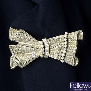 A mid 20th century platinum and gold pavé-set diamond double-clip bow brooch.