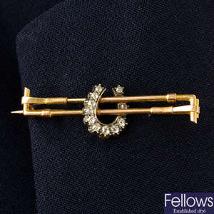 An early 20th century silver and gold old-cut diamond horseshoe and riding crops brooch.