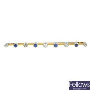 An Early 20th century gold old-cut diamond and sapphire bar brooch.