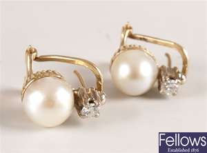 A pair of earrings with a cultured pearl