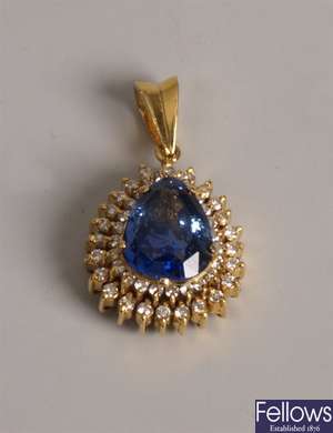 A pear shape sapphire pendant surrounded by two