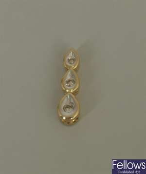 18k gold three stone diamond set pendant, in the