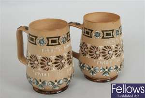 A pair of Doulton Lambeth stoneware mugs, each