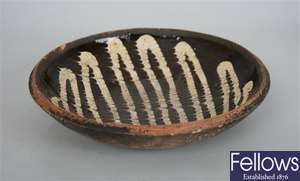 A slipware bowl, the brown glazed ground with
