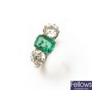 An emerald and diamond three stone ring, centred