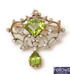An ornate peridot and diamond brooch, with a