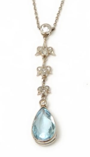 An ornate diamond and aquamarine pendant, with an