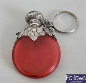 A circular cranberry glass scent bottle with