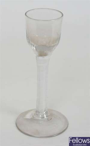 An antique wine glass with rounded fluted bowl on