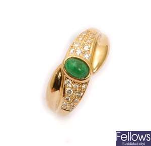 An emerald and diamond cross over design ring,