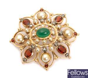A stone set brooch with a central green stone