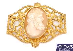 An ornate cameo brooch, comprising a central oval