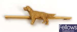 A dog design bar brooch, in a plain bar design