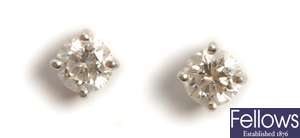 A pair of diamond set stud earrings, with a claw