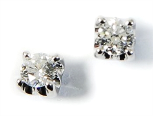 A pair of diamond stud earrings - the two studs
