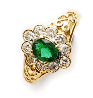 An oval emerald and diamond cluster ring,