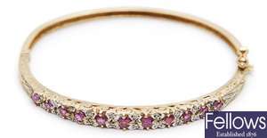 A 9ct gold ruby and diamond set hinged bangle,