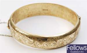 A hinged bangle with scroll engraved detail.