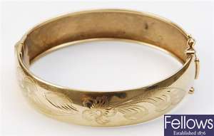 A 9ct gold hinged bangle, with engraved floral