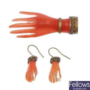 A celluloid hand brooch with matching earrings.
