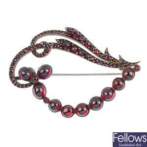 Four items to include a garnet brooch, two green bead necklaces and an imitation drop pendant.