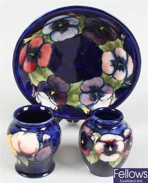 A Moorcroft pottery circular shaped dish, a Moorcroft vase and a similar vase